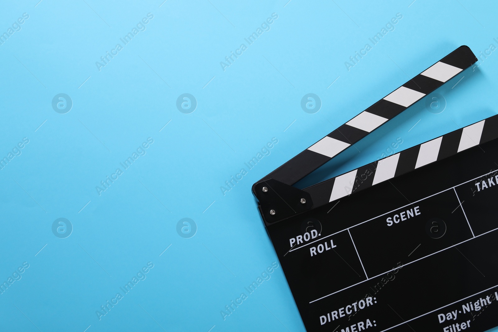 Photo of Clapperboard on light blue background, top view. Space for text