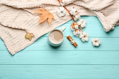 Photo of Flat lay composition with coffee and warm plaid on turquoise wooden table, space for text