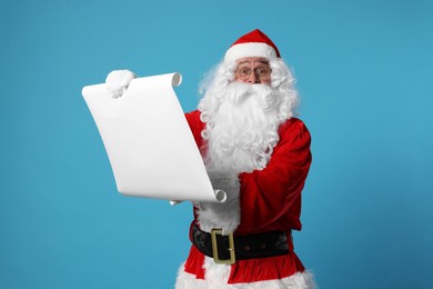 Photo of Merry Christmas. Santa Claus reading wishlist on light blue background