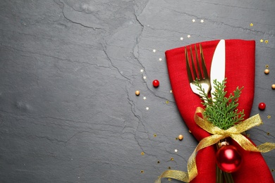 Photo of Cutlery set on grey table, top view with space for text. Christmas celebration