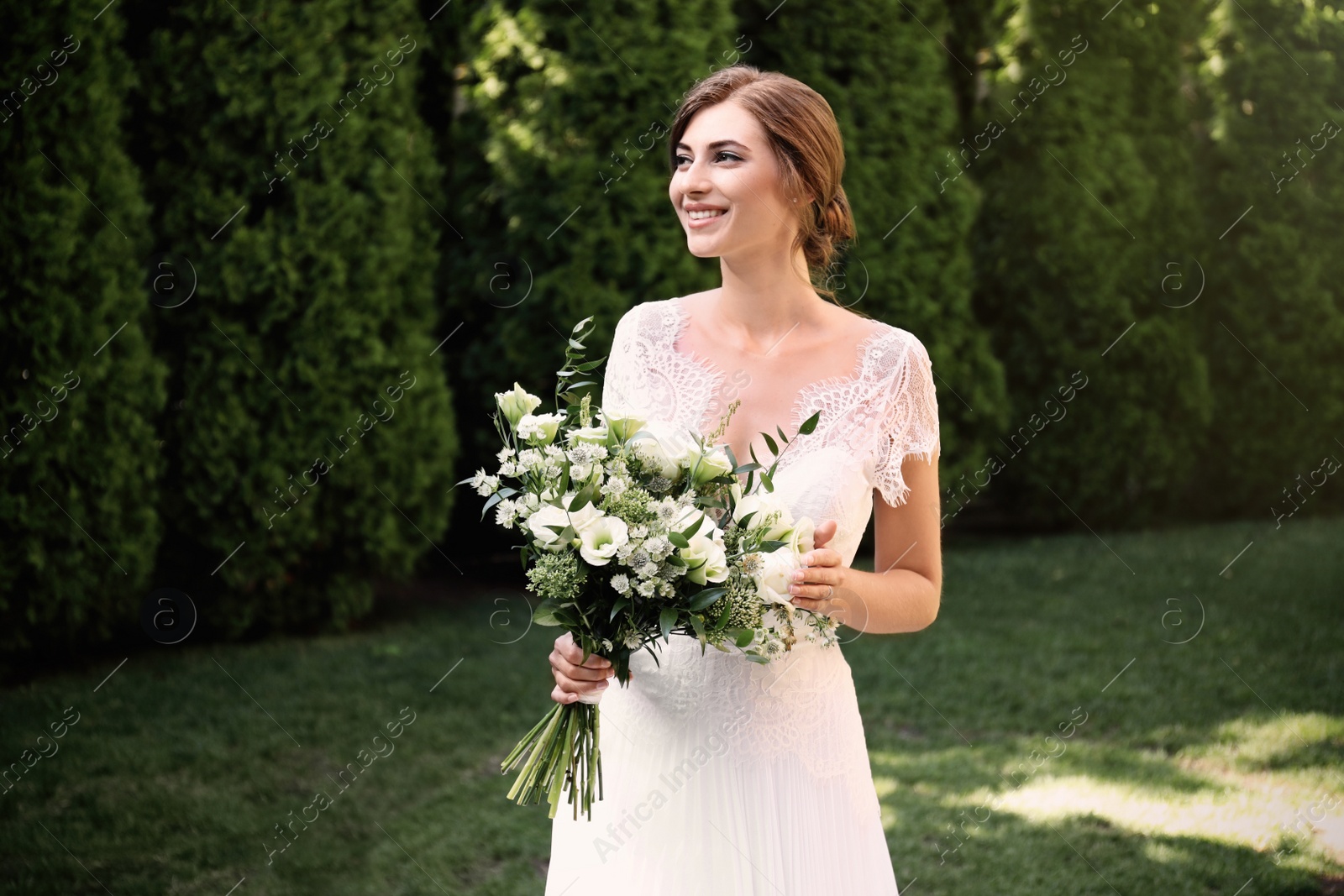 Photo of Gorgeous bride in beautiful wedding dress with bouquet outdoors