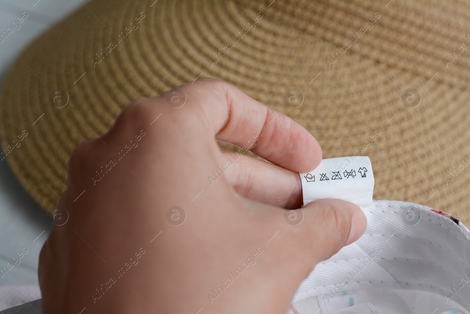 Photo of Woman holding clothing label on garment, closeup