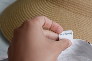 Woman holding clothing label on garment, closeup