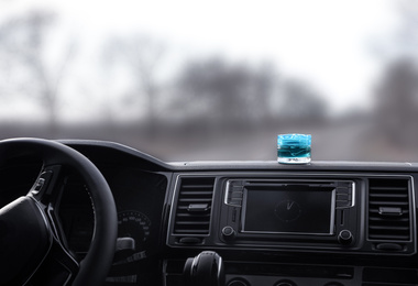 Photo of Stylish air freshener on dashboard in car