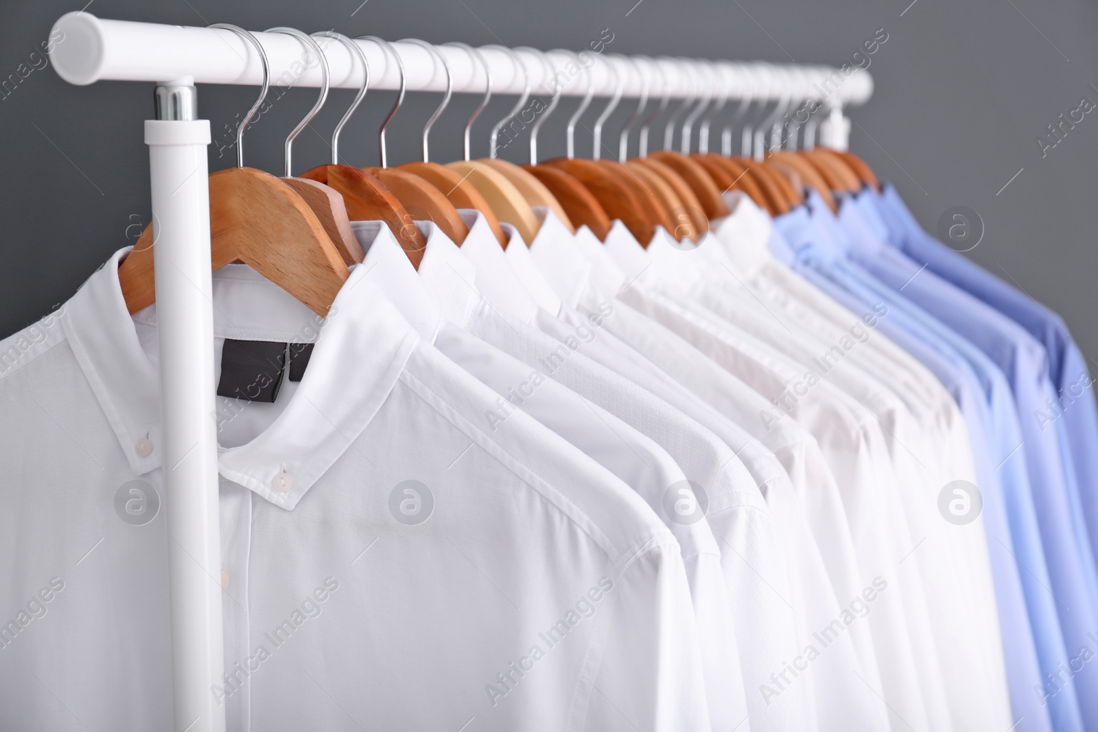 Photo of Rack with clean clothes on hangers after dry-cleaning