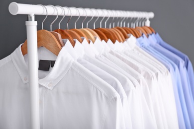 Rack with clean clothes on hangers after dry-cleaning