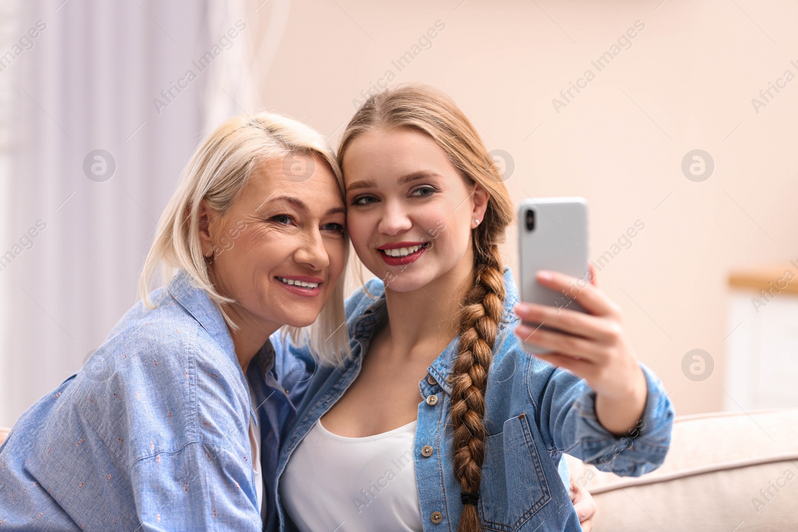 Photo of Happy mother and daughter taking selfie at home