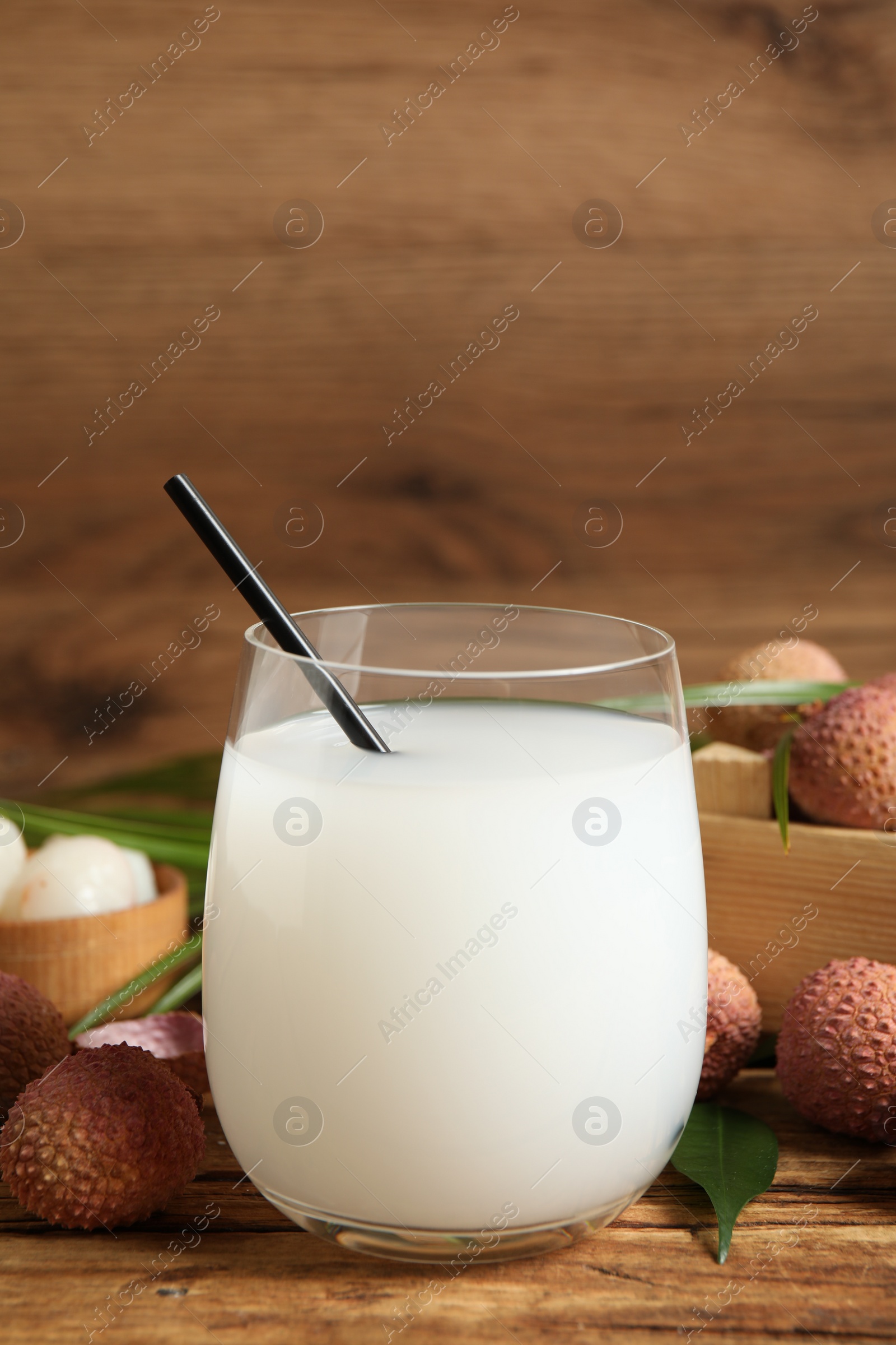 Photo of Lychee juice and fresh fruits on wooden table