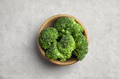 Photo of Fresh green broccoli in bowl on light table, top view