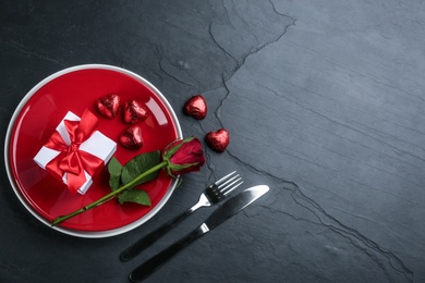 Photo of Beautiful table setting on black background, flat lay with space for text. Valentine's Day dinner