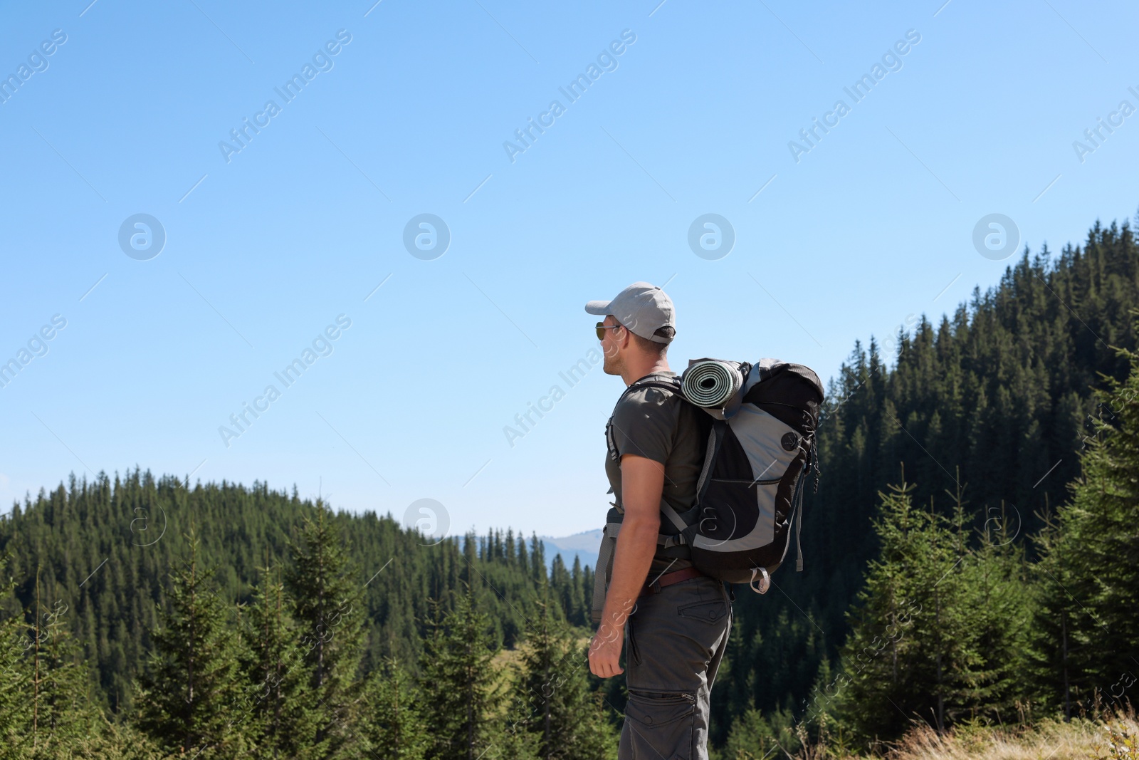 Photo of Tourist with backpack in mountains on sunny day. Space for text