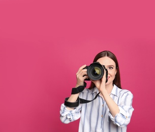Professional photographer taking picture on pink background. Space for text
