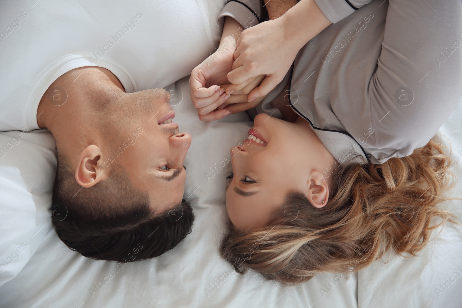 Photo of Lovely couple enjoying time together on bed, above view