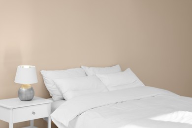 Photo of White soft pillows on cozy bed in room