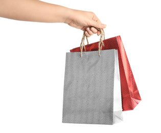 Photo of Woman holding paper shopping bags on white background, closeup. Space for design