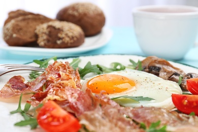 Photo of Plate with fried egg, bacon and vegetables, closeup