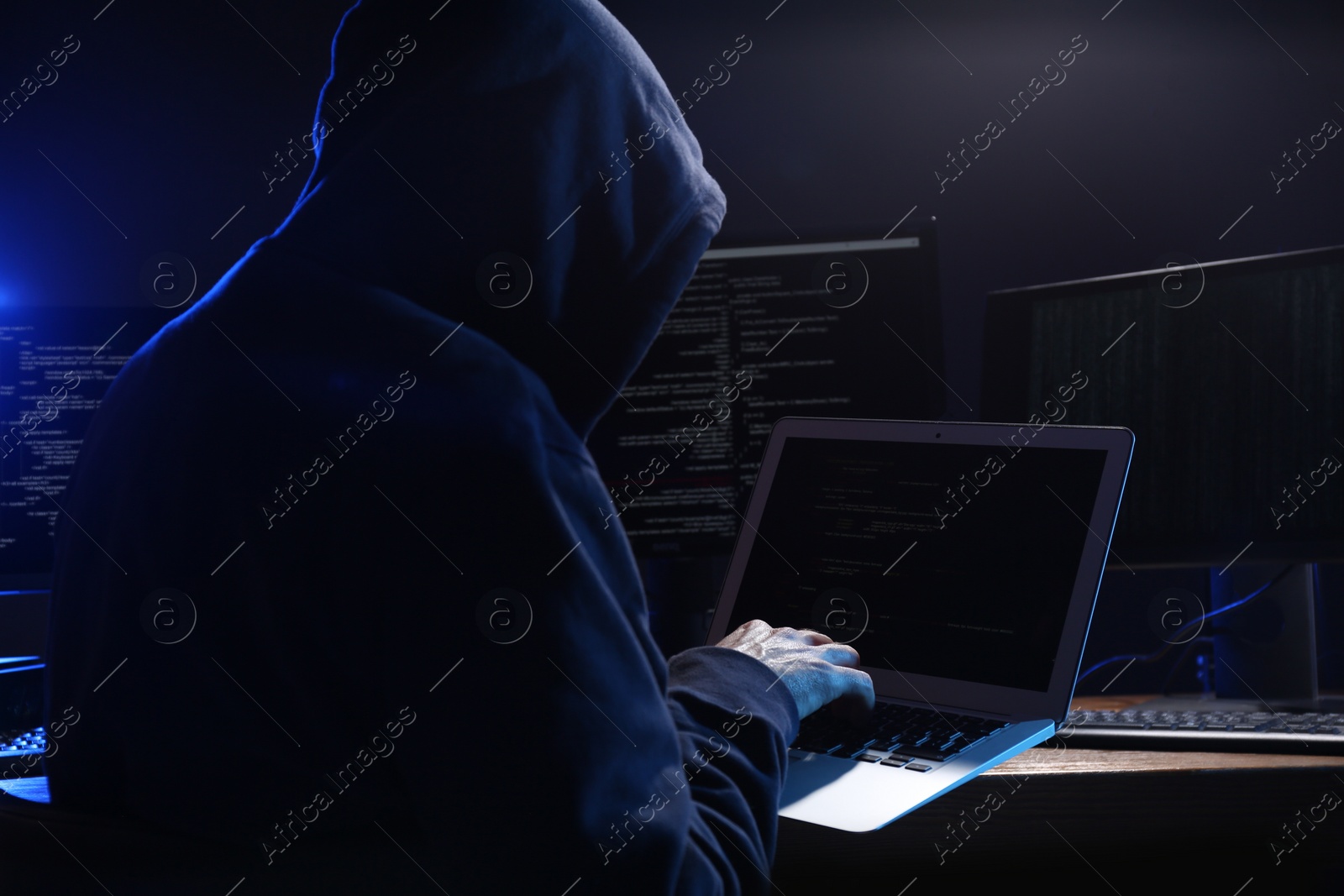 Photo of Hacker with computers in dark room. Cyber crime