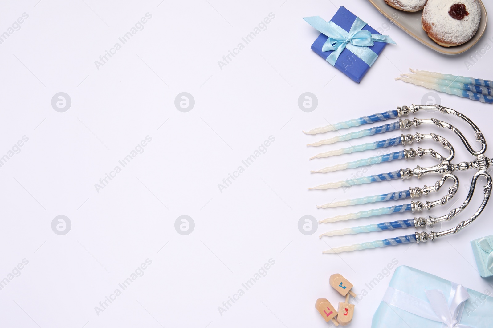 Photo of Flat lay composition with Hanukkah menorah and gift boxes on light background. Space for text