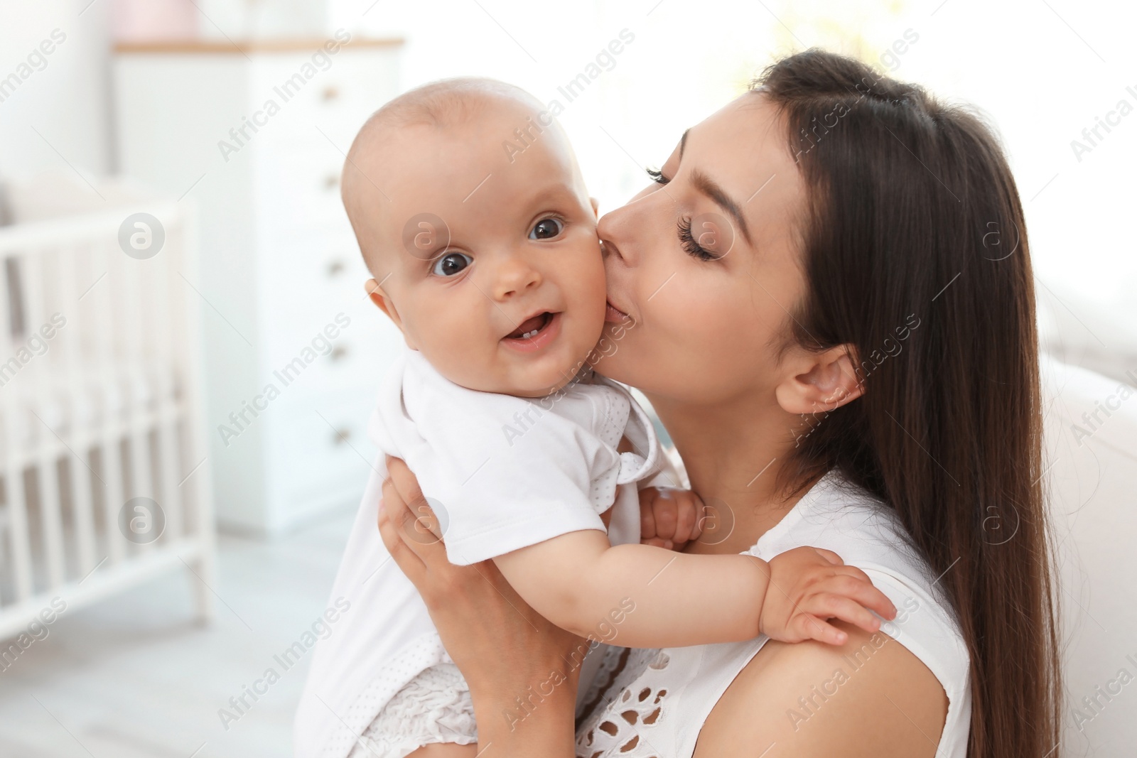 Photo of Young mother with her cute baby girl at home