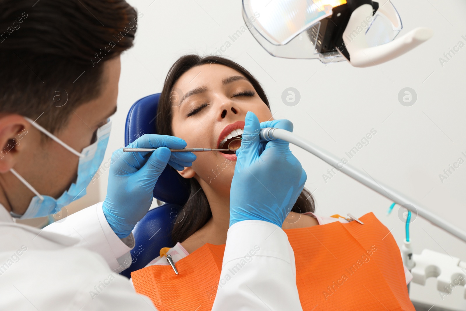 Photo of Professional dentist working with patient in clinic