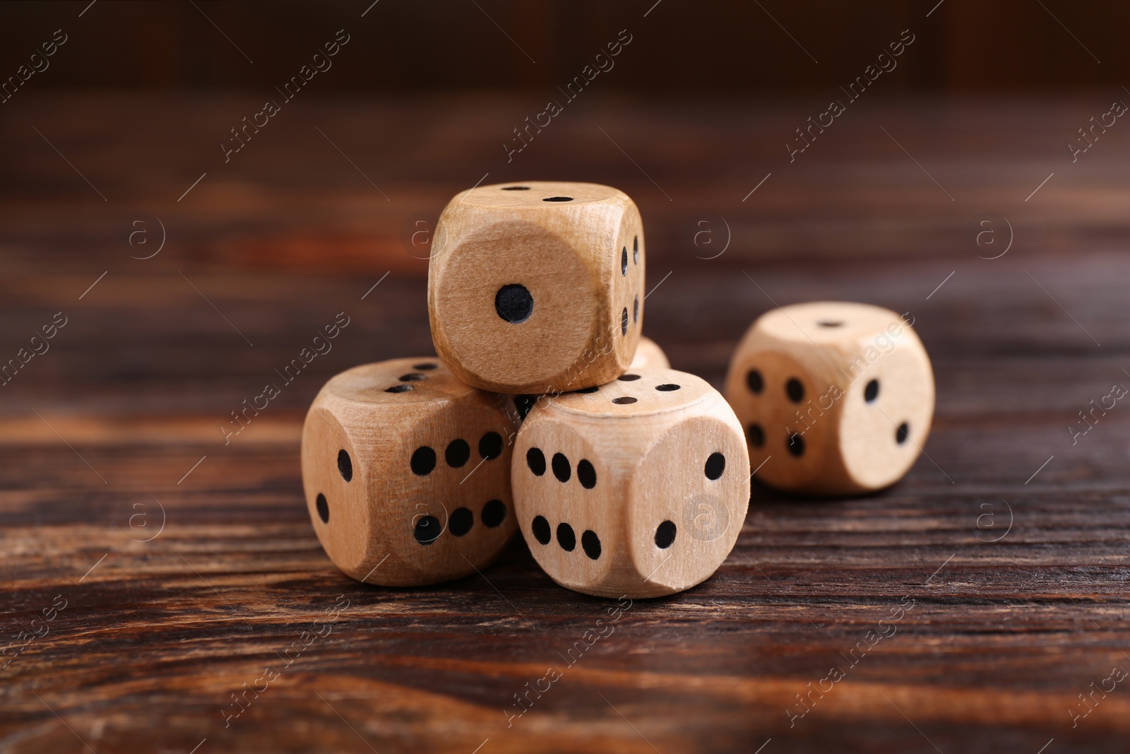 Photo of Many game dices on wooden table, closeup