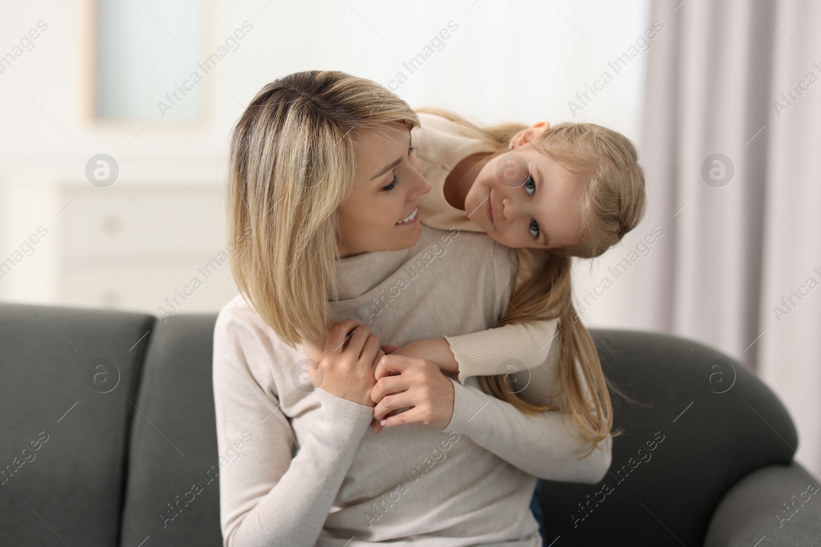 Photo of Happy mother and daughter on sofa at home