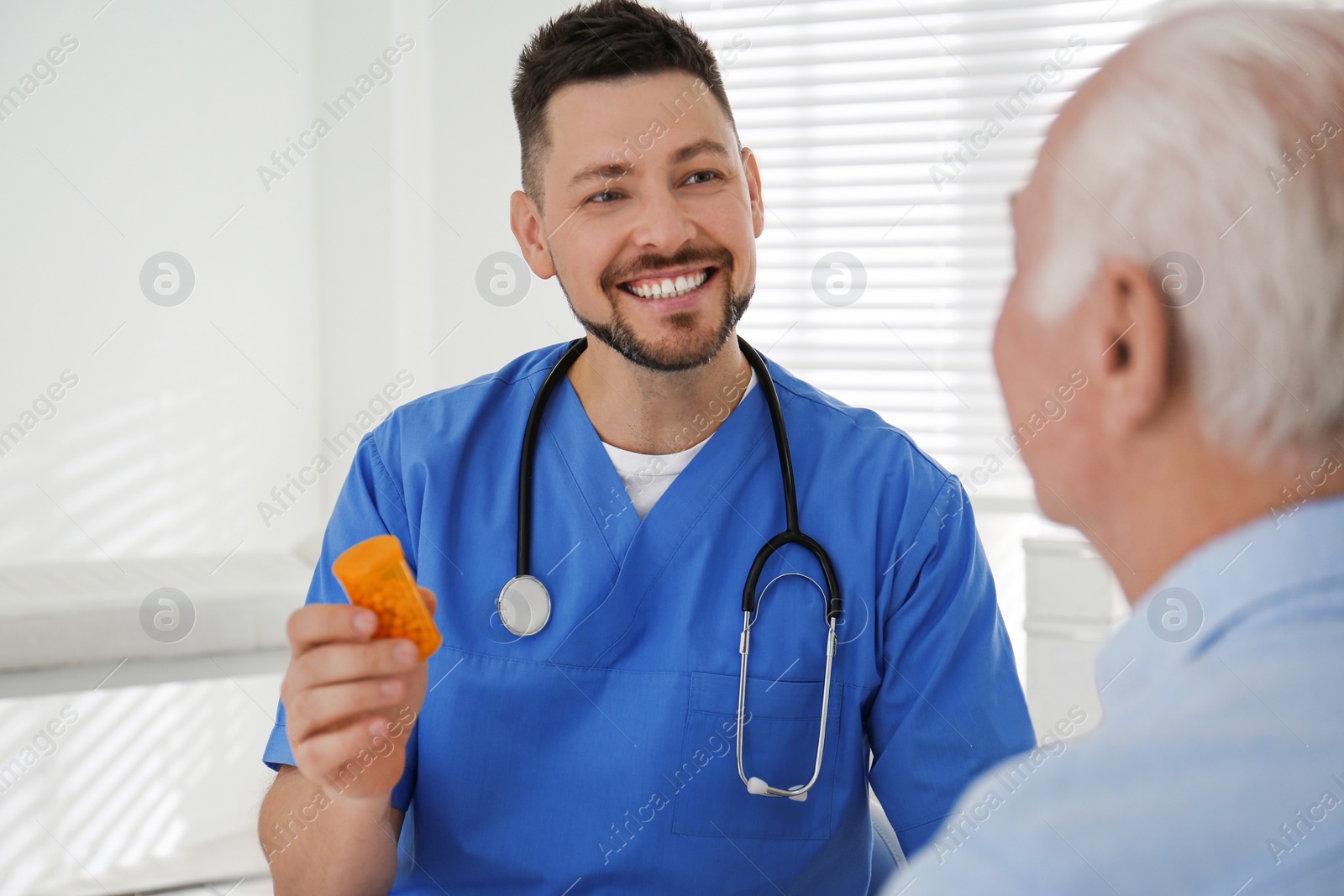 Photo of Doctor giving pills to senior patient in office