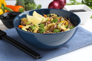 Photo of Stir-fry. Delicious cooked noodles with chicken and vegetables in bowl served on white table, closeup