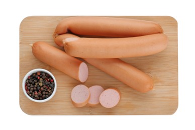 Photo of Wooden board with tasty sausages and peppercorns isolated on white, top view. Meat product