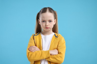 Portrait of sad girl on light blue background