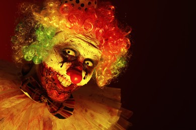 Photo of Terrifying clown in darkness. Halloween party costume