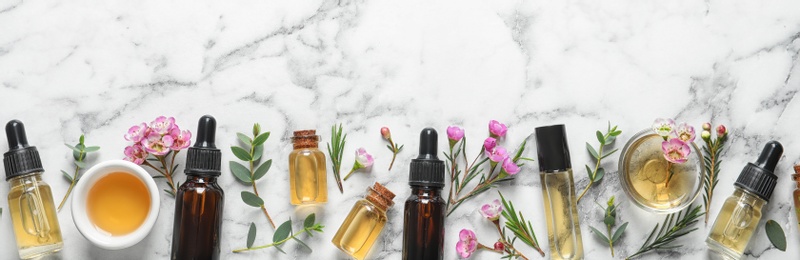 Photo of Flat lay composition with bottles of natural tea tree oil and space for text on white marble background