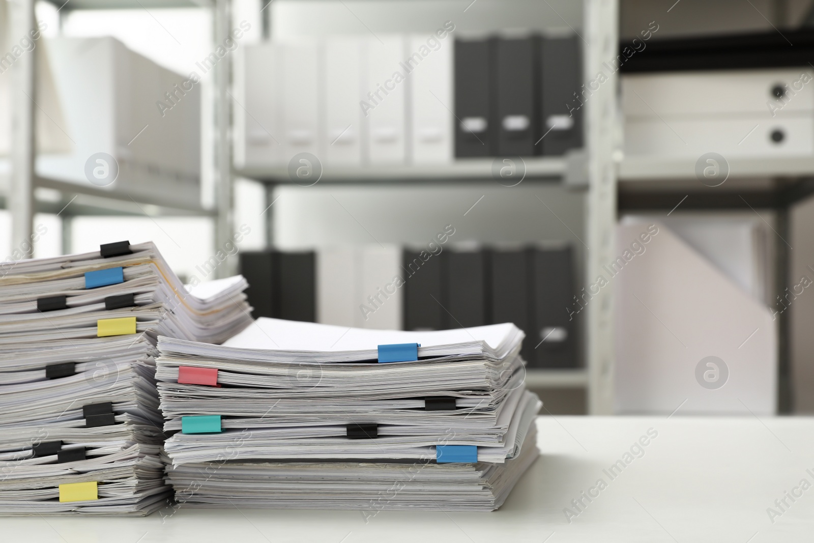 Photo of Stacks of documents with paper clips on office desk. Space for text