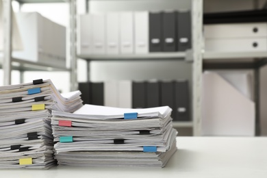 Stacks of documents with paper clips on office desk. Space for text