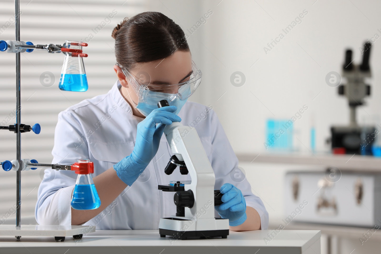 Photo of Young scientist working with microscope in laboratory