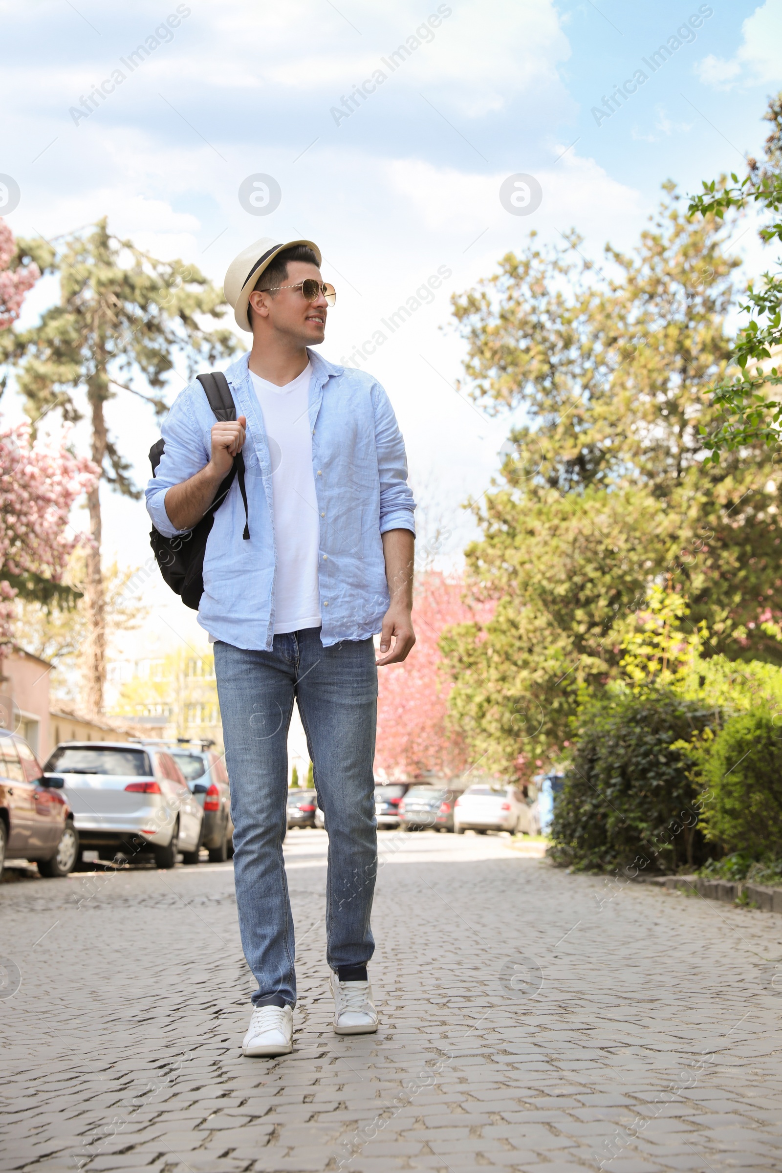 Photo of Tourist with backpack walking on city street