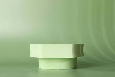 Photo of Presentation of product. Podium and shadows on green background. Space for text