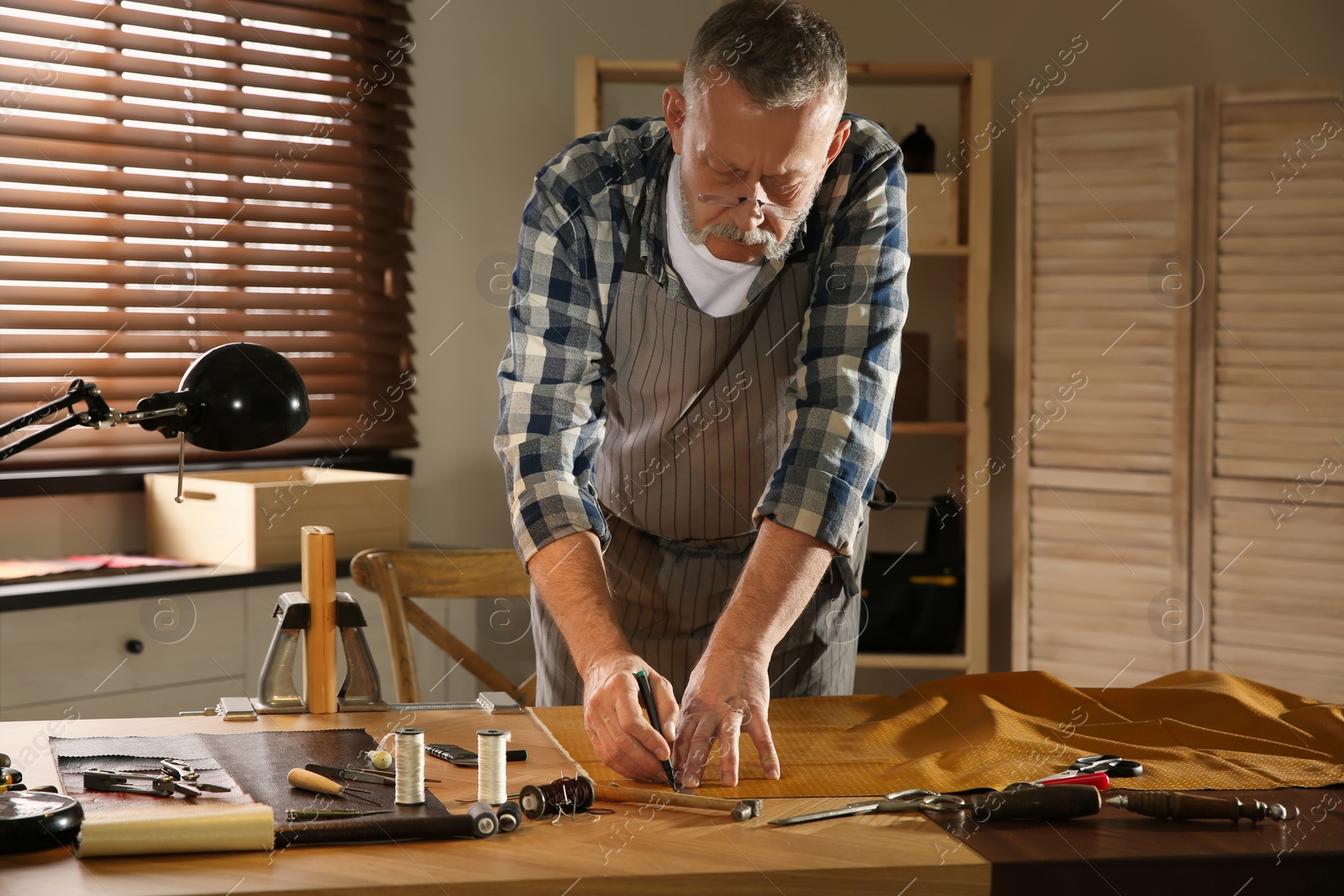 Photo of Man working with piece of leather in workshop