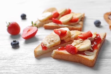 Photo of Tasty toast bread with banana and strawberry on light background, closeup