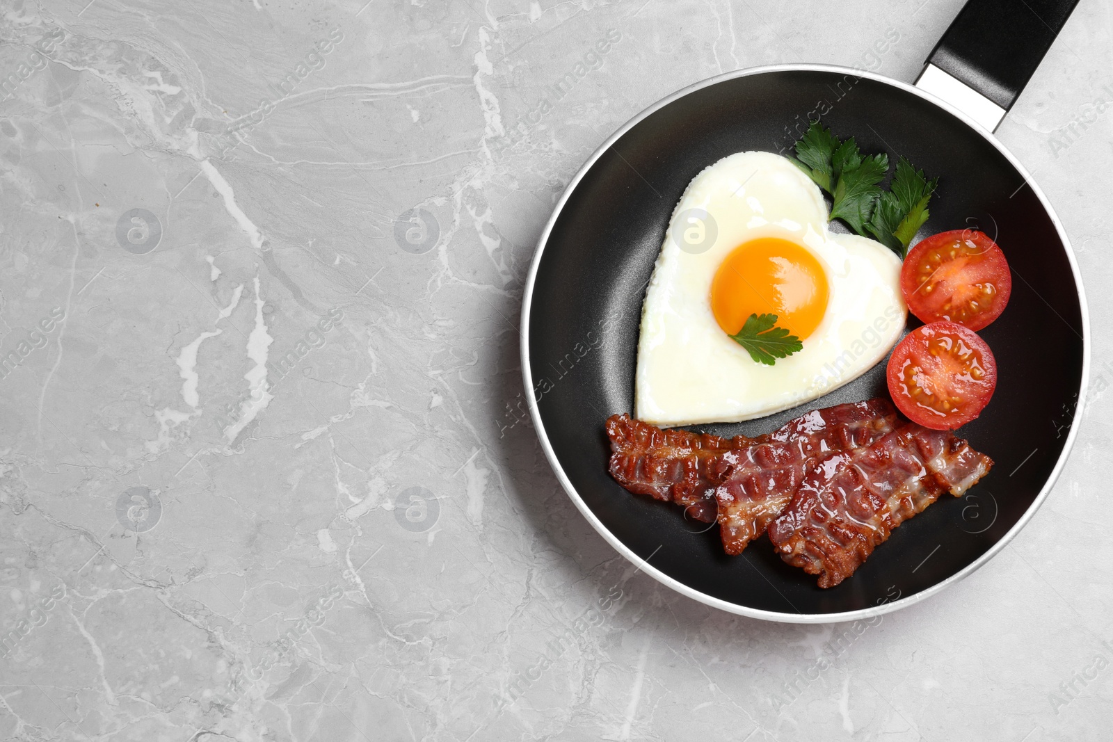 Photo of Tasty breakfast with heart shaped fried egg on grey table, top view. Space for text