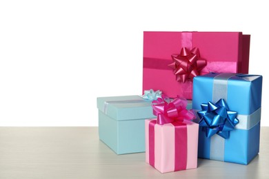 Pink and light blue gift boxes on wooden table against white background, space for text