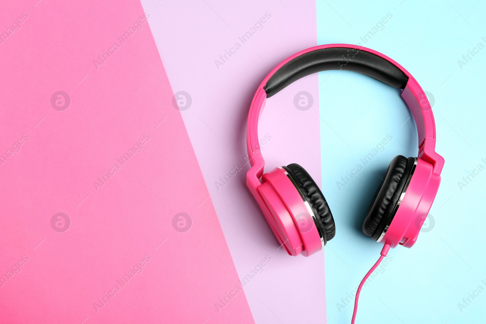 Photo of Stylish headphones on color background, top view. Space for text