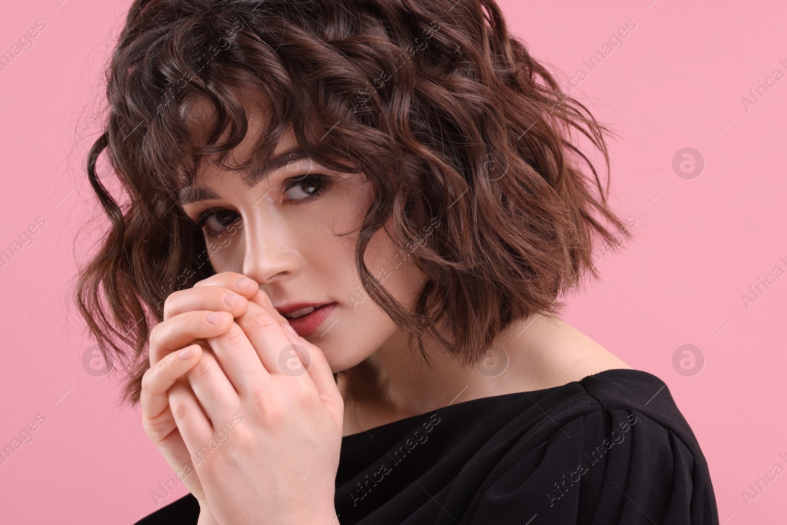 Photo of Beautiful young woman with wavy hairstyle on pink background