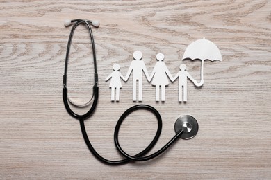 Photo of Paper family cutout and stethoscope on white wooden background, flat lay. Insurance concept