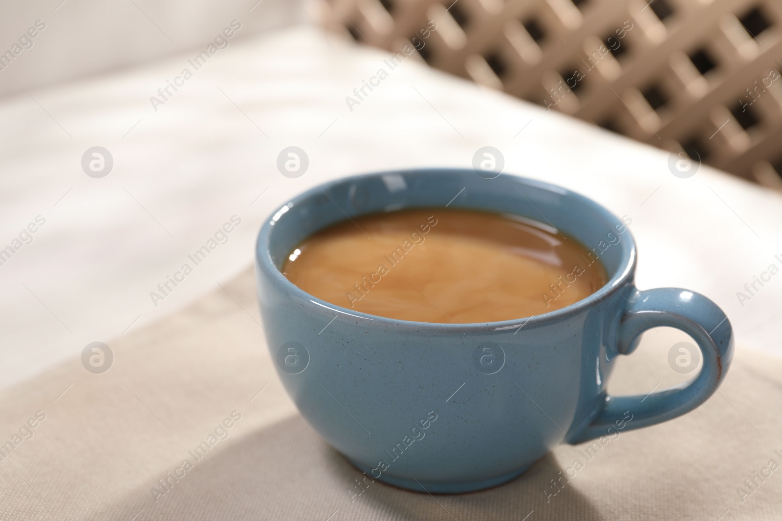 Photo of Delicious coffee in cup on white table, closeup. Space for text