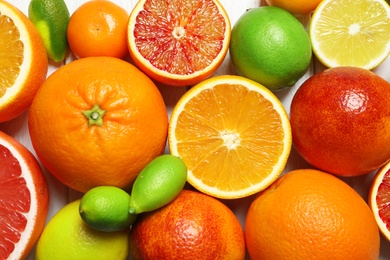 Photo of Many different citrus fruits as background, top view