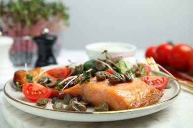 Photo of Delicious salmon with salad and capers on table, closeup