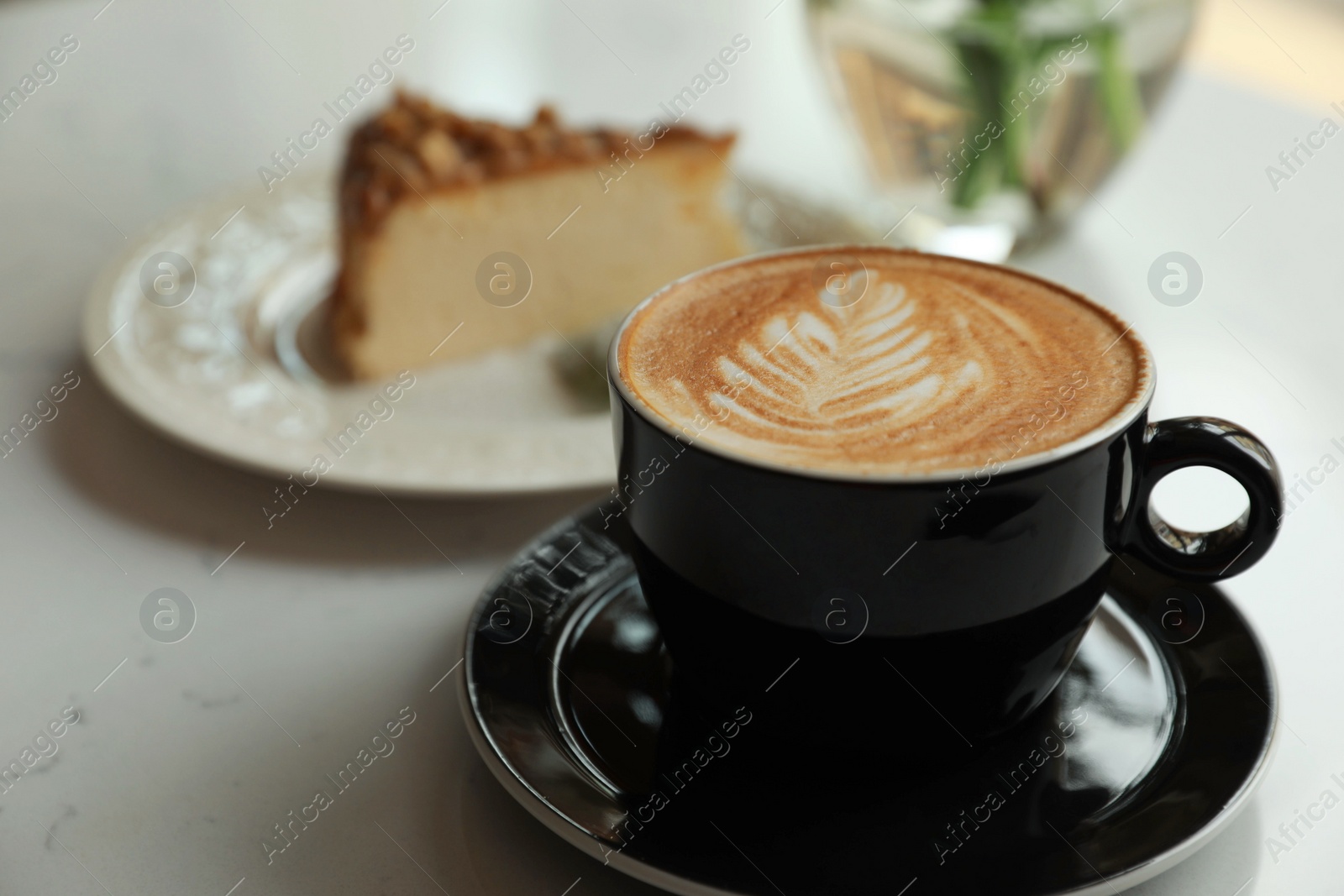 Photo of Cup of fresh coffee and dessert on white table, closeup