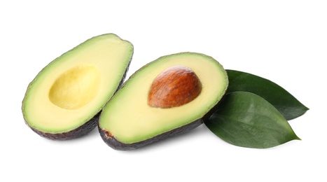 Cut hass avocado and green leaves on white background