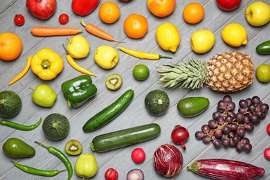 Photo of Rainbow collection of ripe fruits and vegetables on grey background, top view